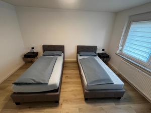 two beds sitting in a room with a window at Ferienwohnung Laufenburg in Laufenburg