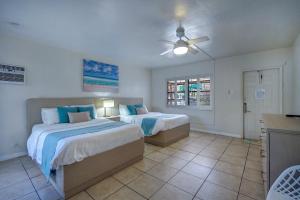 a bedroom with two beds and a ceiling fan at Sea Garden by the Sea in Fort Lauderdale