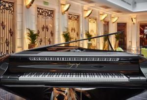 a black piano in a lobby with a building at Aria Hotel Budapest by Library Hotel Collection in Budapest