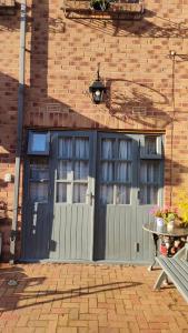 a garage with a gray door and a brick building at Daiches Braes Brunstane Portobello in Edinburgh