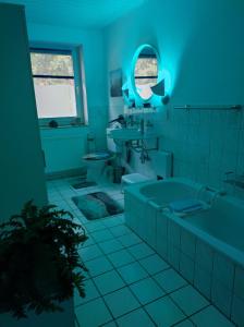 a blue bathroom with a tub and a sink at Entspannen & Wohlfühlen in der Lüneburger Heide in Vierhöfen