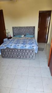 a bedroom with a bed with a blue comforter at villa tulipe in Ain Sokhna