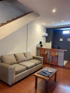 a living room with a couch and a table at Departamento moderno y con excepcional vista a la montaña in Guaymallen