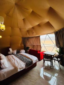 a bedroom with a large bed and a table at RAMA CAMP wadi rum in Disah