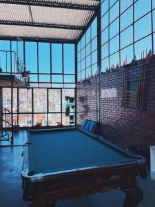 a pool table in a large room with windows at Lobo Hostel La Paz in La Paz