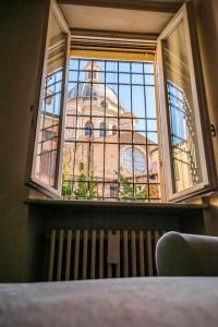 a window with a view of a building through it at [Vista sulla Basilica] in Mantova