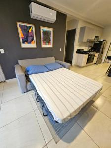 a large bed in a room with a kitchen at Departamento Puesta del Sol Gdl in Guadalajara