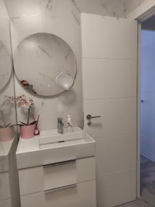 a white bathroom with a sink and a mirror at Primera línea de playa centro in Noja