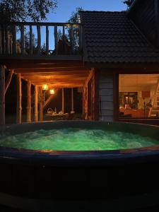 una bañera de hidromasaje frente a una casa por la noche en Metsaräägu Wellness, 