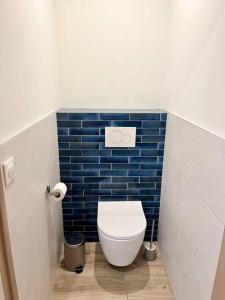 a bathroom with a toilet in a blue tiled wall at Résidence Domaine Iratzia Erromardie - Appartement T2 in Saint-Jean-de-Luz +17 photos