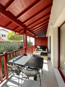 a patio with a table and chairs on a balcony at Résidence Domaine Iratzia Erromardie - Appartement T2 in Saint-Jean-de-Luz