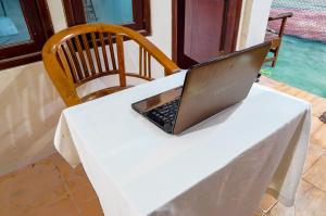 a laptop computer sitting on top of a white table at OYO 93161 Nurul Hikmah Homestay Syariah & Sport Center in Sedati