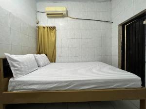 a small bed in a room with at Hotel O Kost Maharaja Near Maros in Makassar