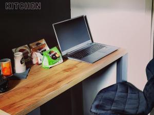 a laptop computer sitting on top of a wooden desk at THE BLACKTAGON Cozy Apartment in Frankfurt