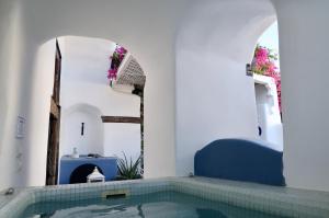 a bathroom with a swimming pool in a house at Villa Orpheus Santorini in Megalochori
