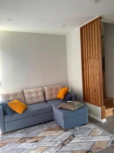 a living room with a blue couch and orange pillows at Liana Polo Villas Parklane in Batumi +22 photos
