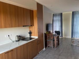 a kitchen with wooden cabinets and a table and a table sidx sidx sidx at Liana Polo Villas Parklane in Batumi