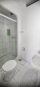 a bathroom with a shower and a toilet and a sink at Hotel Kolman in Capão da Canoa