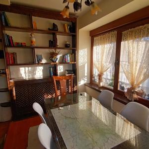 uma sala de jantar com uma mesa de vidro e cadeiras em La Artesonada casa con finca (Puebla de Sanabria). em Puebla de Sanabria