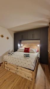 Un dormitorio con una gran cama de madera con almohadas rojas en Desiree 2 vda morgex cir 12, en Morgex