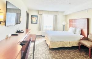 a hotel room with a bed and a desk at Days Inn by Wyndham Grande Prairie in Grande Prairie