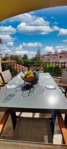 a table with a bowl of bananas and wine glasses at Casa Palmu apartment - A peaceful and relaxing oasis in Golf del Sur, Tenerife in San Miguel de Abona