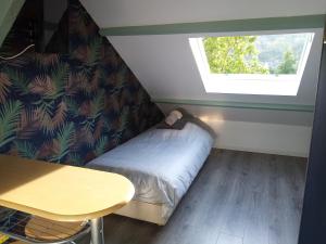 - une petite chambre avec un lit et une fenêtre dans l'établissement Havre de paix au bord de l'Eure-chambres d'hôtes-petit studio mansardé-logements insolites, à Neuilly