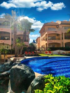 a swimming pool in front of a building at Casa Palmu apartment - A peaceful and relaxing oasis in Golf del Sur, Tenerife in San Miguel de Abona