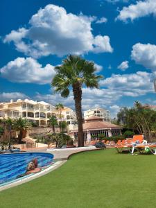 Casa Palmu apartment - A peaceful and relaxing oasis in Golf del Sur, Tenerife في سان ميغيل ذي أبونا: منتجع فيه نخلة ومسبح