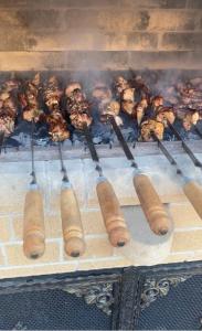 a grill with a bunch of meat and tongs at Nice villa in Yerevan