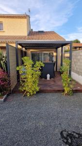 a house with a wooden deck with plants at appartement pour 4 avec terrasse in Chanos-Curson