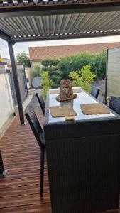 a table with a hat on it on a patio at appartement pour 4 avec terrasse in Chanos-Curson +6 photos