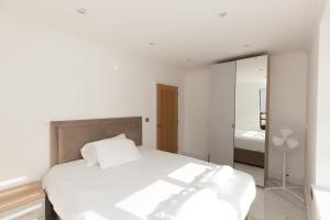 una camera con letto bianco e specchio di The Mayfair a Six Mile Bottom