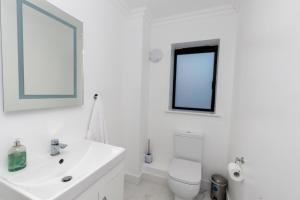 bagno bianco con lavandino e servizi igienici di The Mayfair a Six Mile Bottom