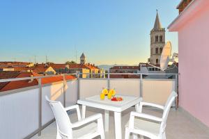 a white table and chairs on a balcony with a view at Sea Gate Studio in Zadar