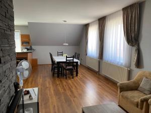 a living room with a table and chairs and a kitchen at Spacious Apartment in Town Centre in Nové Zámky