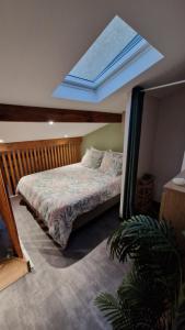 a bedroom with a bed with a skylight in the ceiling at appartement pour 4 avec terrasse in Chanos-Curson