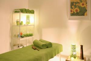 a room with a bed with green sheets and a shelf at Makronisos Village in Ayia Napa