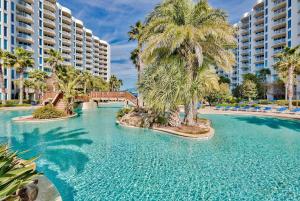 a swimming pool with palm trees in a resort at Beautiful Junior 2BR/2BA Palms Resort in Destin in Destin