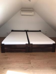 a bed in a room with a white mattress at Spacious Apartment in Town Centre in Nové Zámky