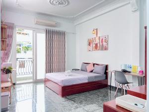 a white room with a bed and a desk and a table at Tumy homestay Sai Gon in Ho Chi Minh City