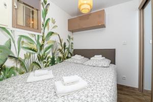 een slaapkamer met 2 bedden en witte handdoeken bij Le Verd'ô - Piscine - Plage - Parking - Wifi - MyBestLoc in Six-Fours-les-Plages