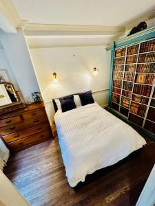 een slaapkamer met een bed en een raam met boeken bij Perfect West End Launchpad in Londen