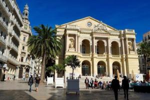 un grand bâtiment avec des gens qui marchent devant dans l'établissement Budgetbnb 184, confortable studio proche opéra clim, à Toulon