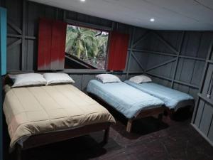 2 camas en una habitación con ventana en Chocolate Village & pool, en Jiménez