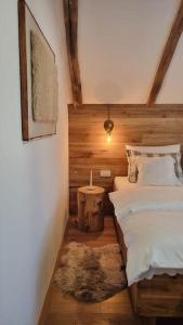 a bedroom with a white bed and a rug at Guest Accommodation Butina in Kuterevo