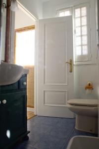 ein Bad mit einem WC, einem Waschbecken und einer Tür in der Unterkunft El Zoco in Baños de la Encina