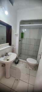 a bathroom with a sink and a toilet and a shower at Hotel Kolman in Capão da Canoa
