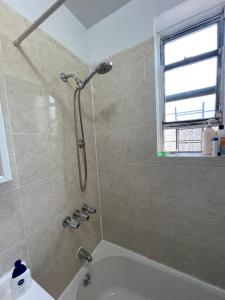 een badkamer met een douche en een bad bij Deluxe Manhattan room in New York