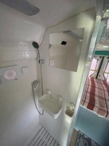 ein kleines Bad mit einem Waschbecken und einem Bett in der Unterkunft Дом на колесах (Караван) in Puerto de Sagunto